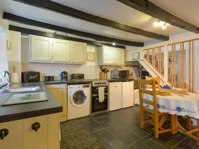 a kitchen with a washer and dryer in it at Churchgate Cottage in Bodmin