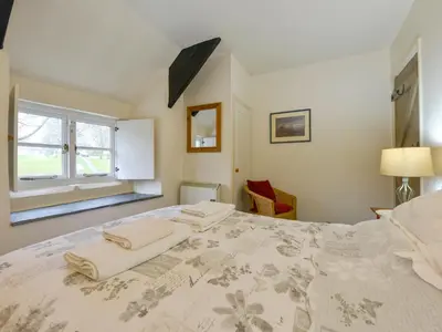a bedroom with a large bed with two towels on it at Churchgate Cottage in Bodmin