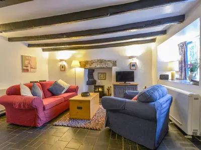 a living room with two couches and a fireplace at Churchgate Cottage in Bodmin