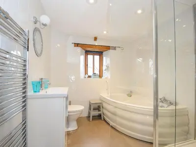 a bathroom with a tub and a toilet and a sink at Swallow Barn in Saint Kew