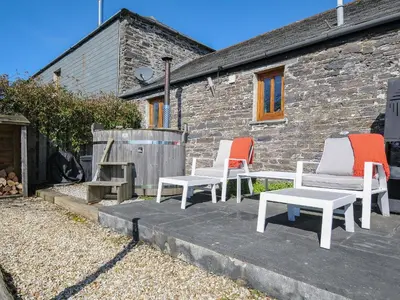 three chairs sitting on a patio in front of a building at Swallow Barn in Saint Kew
