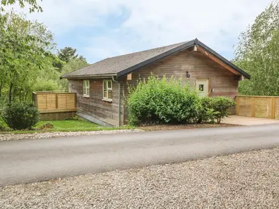 a small wooden house on the side of a road at 1 Lake View in Looe