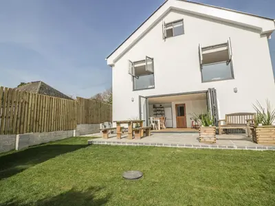 a white house with a patio and a fence at The Beach Halt in Perranporth