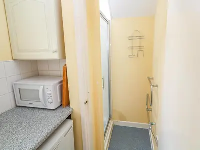 a small kitchen with a microwave and a window at Higher Lampra in Helston
