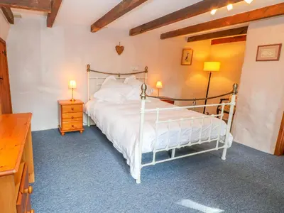 a bedroom with a white bed and two lamps at Higher Lampra in Helston