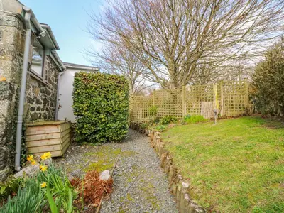 a backyard with a fence and a yard at Higher Lampra in Helston