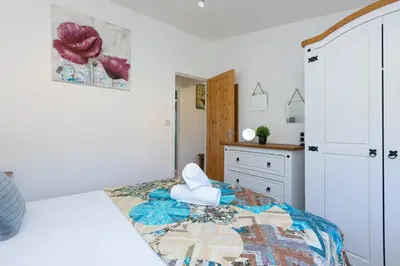 a bedroom with a bed and a dresser at Costentyn, Tor Down Quarry in Bodmin