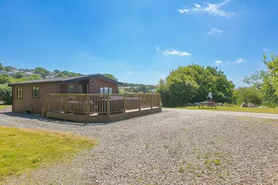 a small cabin with a deck and a bench at Costentyn, Tor Down Quarry in Bodmin