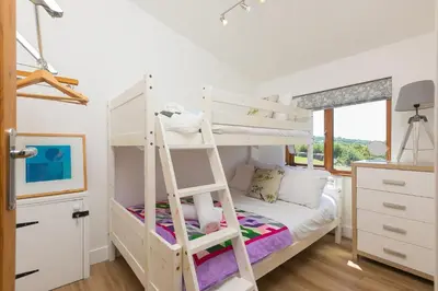 a bedroom with a bunk bed with a ladder at Costentyn, Tor Down Quarry in Bodmin