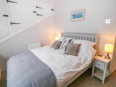 a bedroom with a white bed and a staircase at Blue Anchor in Saint Enoder