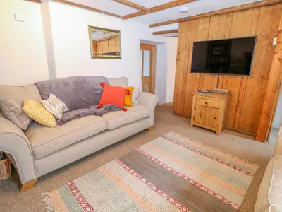 a living room with a couch and a flat screen tv at Blue Anchor in Saint Enoder