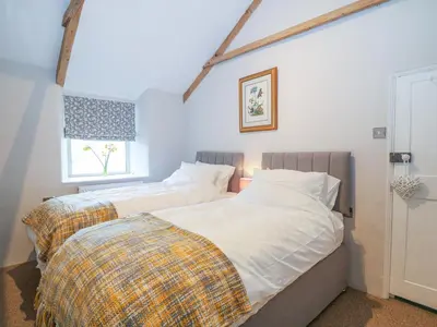 a bedroom with two beds and a window at Blue Anchor in Saint Enoder
