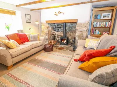 a living room with a couch and a fireplace at Blue Anchor in Saint Enoder