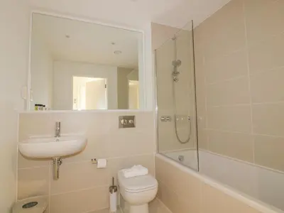 a bathroom with a toilet and a sink and a shower at Chapel Rock View, The Dunes in Perranporth