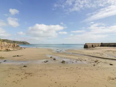 a sandy beach with the ocean in the background at Brambles in Gorran Haven
