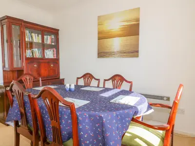 a dining room with a blue table and chairs at Brambles in Gorran Haven