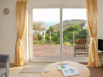 a living room with a large sliding glass door at Brambles in Gorran Haven