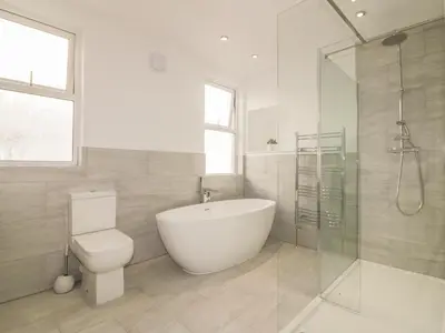 a bathroom with a tub and a toilet and a shower at Chy-an-Brae in Newquay