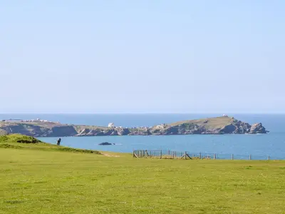 a grassy field with a view of a body of water at Ocean Seven in Newquay