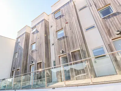 an apartment building with wooden panels on the side of it at Ocean Seven in Newquay