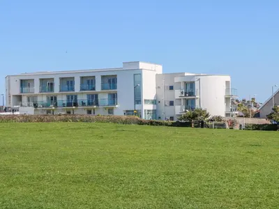 a building with a grass field in front of it at Ocean Seven in Newquay