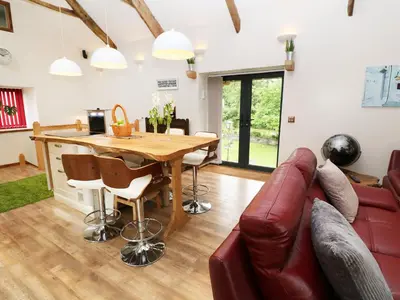 a living room with a wooden table and a couch at The Cart House in Liskeard