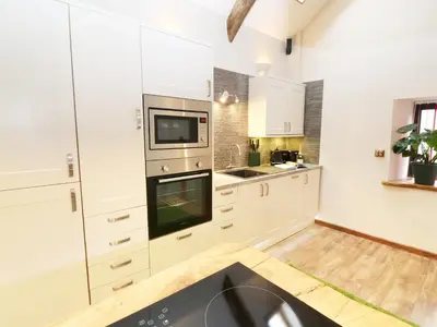a kitchen with white cabinets and a sink at The Cart House in Liskeard