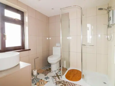 a bathroom with a toilet and a glass shower at Little May in Newquay