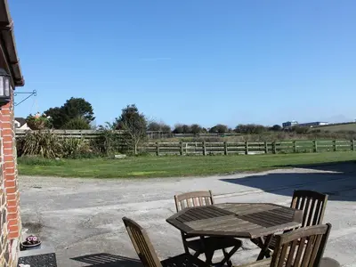 a wooden table and chairs on a patio at Little May in Newquay