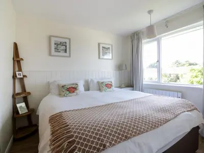 a bedroom with a bed with a large window at Keelyn in Crantock