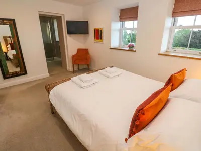 a bedroom with two beds and a mirror at Silvermine House in St Austell