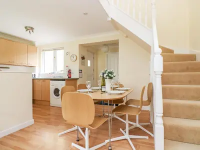 a kitchen and dining room with a table and chairs at Pugwash Cottage in Falmouth