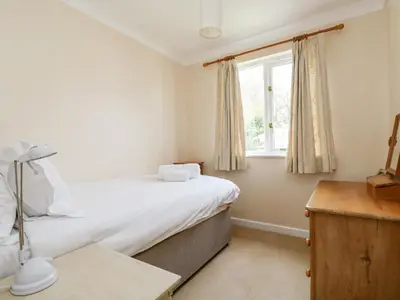 a bedroom with a bed and a window at Pugwash Cottage in Falmouth
