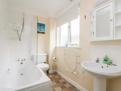 a bathroom with a sink and a tub and a toilet at Pugwash Cottage in Falmouth