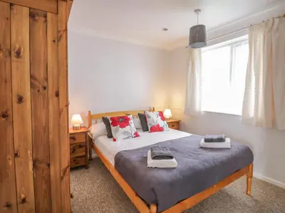 a bedroom with a bed and a window at Ducks Ditty in Liskeard