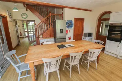 a kitchen with a large wooden table and chairs at Beggars Roost in Truro