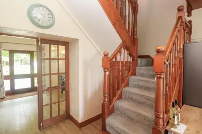 a staircase in a home with a clock on the wall at Beggars Roost in Truro