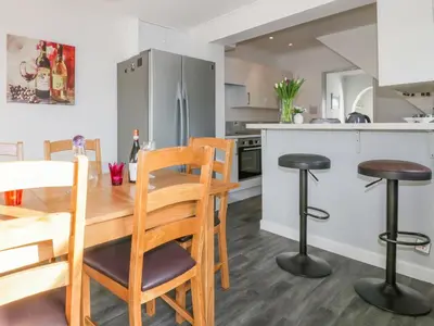 a kitchen and dining room with a wooden table and chairs at Bayview in St Austell