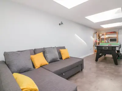 a living room with a gray couch with yellow pillows at Bayview in St Austell
