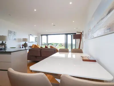 a kitchen and living room with a white table and chairs at Apartment no 21 in Newquay