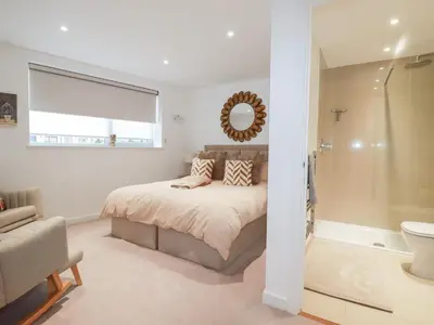 a bedroom with a bed and a shower and a mirror at Apartment no 21 in Newquay