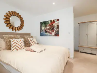 a bedroom with a white bed with a mirror on the wall at Apartment no 21 in Newquay