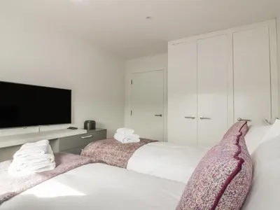 a bedroom with two beds and a flat screen tv at Onshore 7 in Newquay