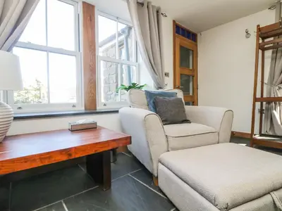 a living room with two chairs and a coffee table at Miner's Rest in Camborne