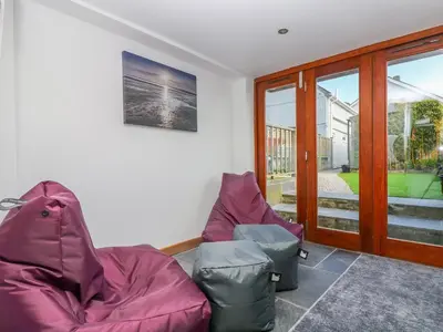 a living room with two chairs and a window at Miner's Rest in Camborne