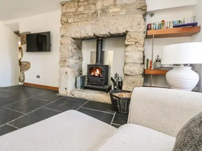 a living room with a stone fireplace at Miner's Rest in Camborne