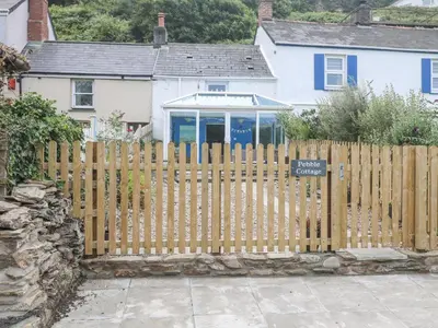 a wooden fence in front of a house at Pebble Cottage in Redruth