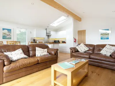 a living room with two brown couches and a table at 3 Valley View in Looe