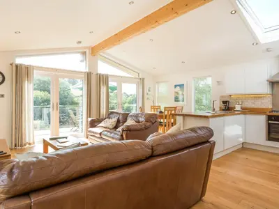 a living room with a couch and a kitchen at 3 Valley View in Looe