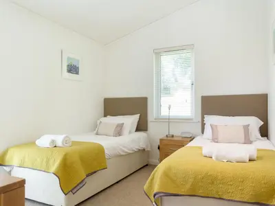 a bedroom with two beds and a window at 3 Valley View in Looe